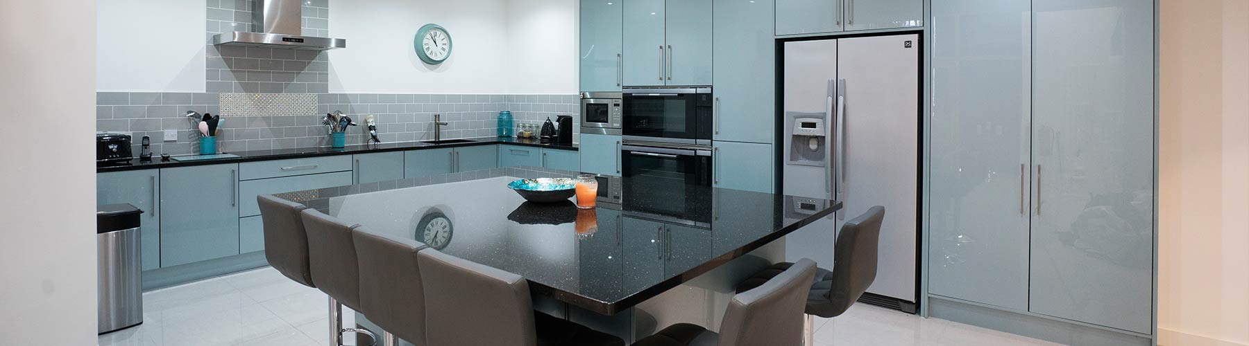Large blue gloss kitchen with granite worktops and large island.